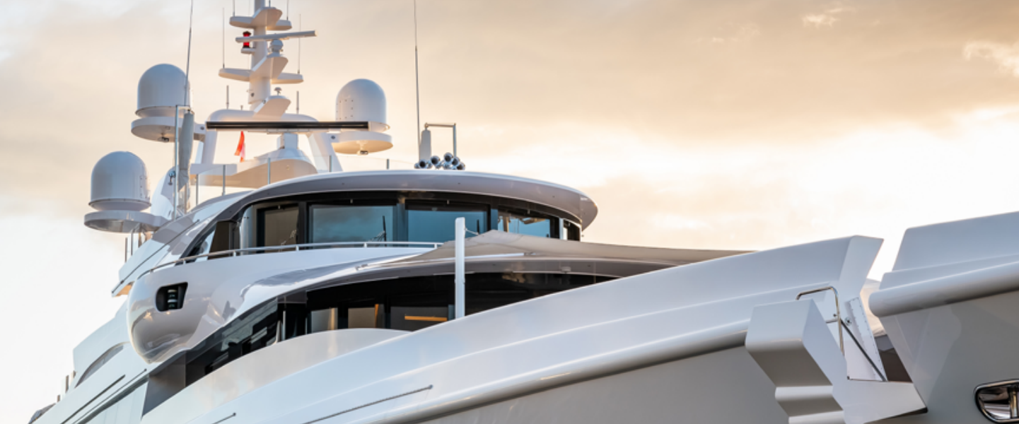 The profile of a superyacht against an evening sky